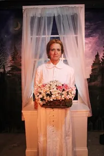 Photo of actress Betsey Means dressed as poet Emily Dickinson holding a basket of flowers